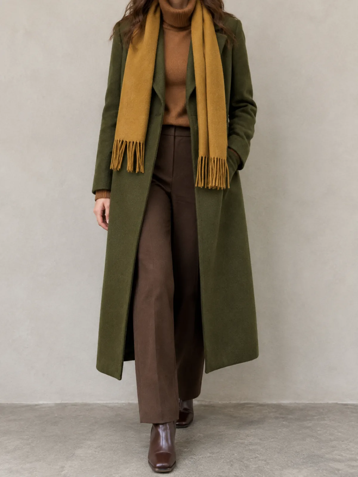 Warm Autumn cold weather outfit: moss green wool coat, mustard scarf, caramel turtleneck and chocolate trousers